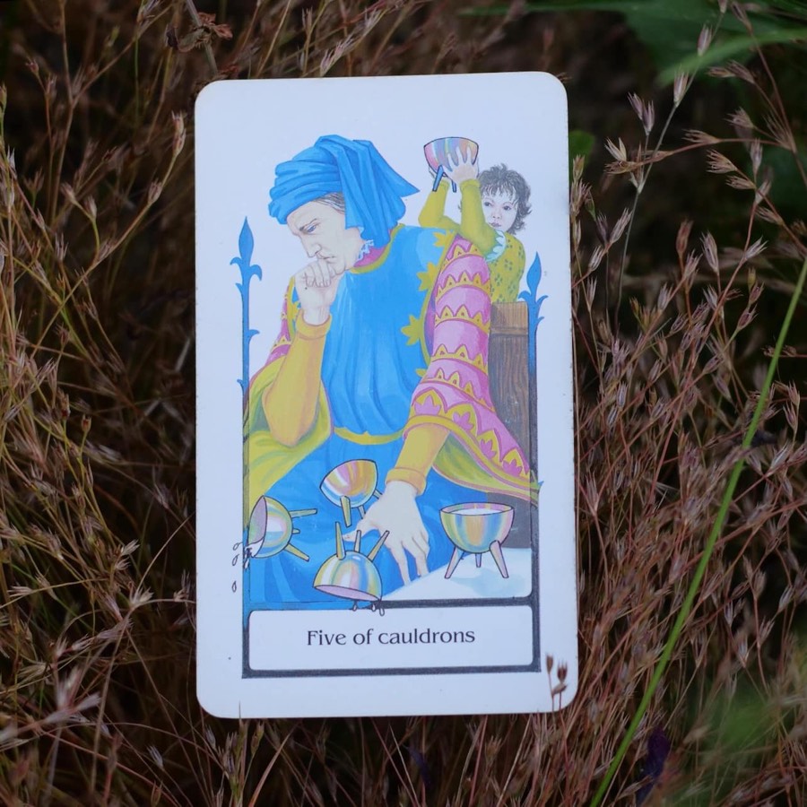 The Five of Cups tarot card photographed outdoors