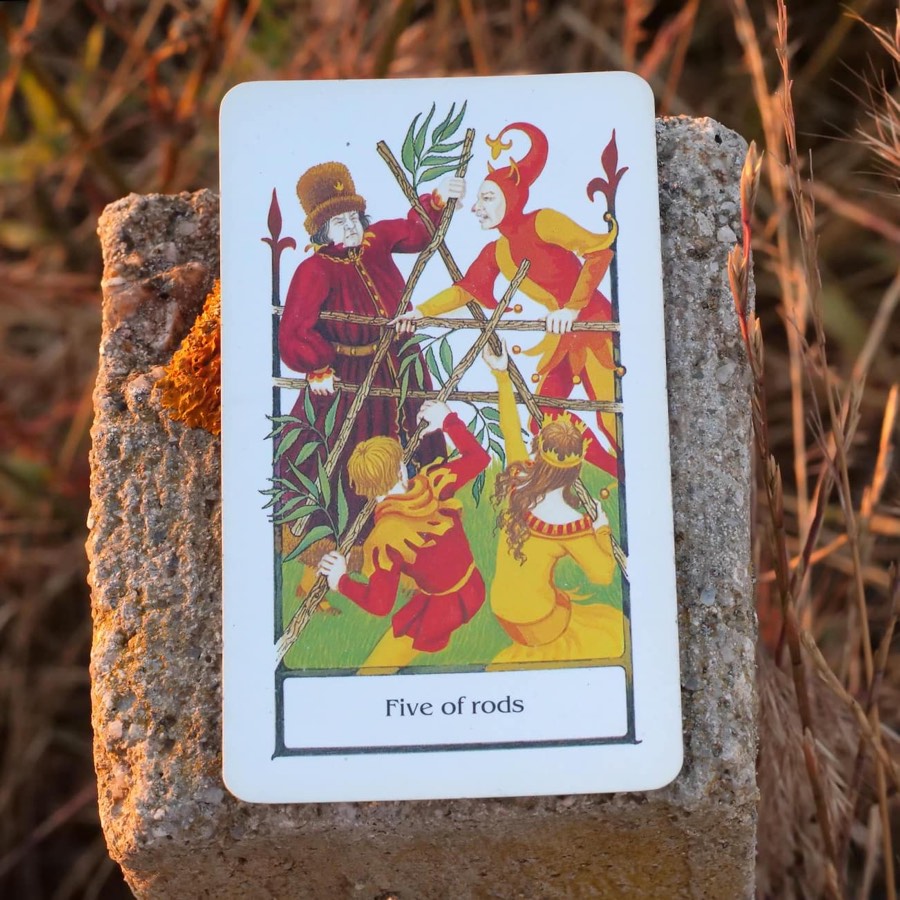 The Five of Wands tarot card photographed outdoors