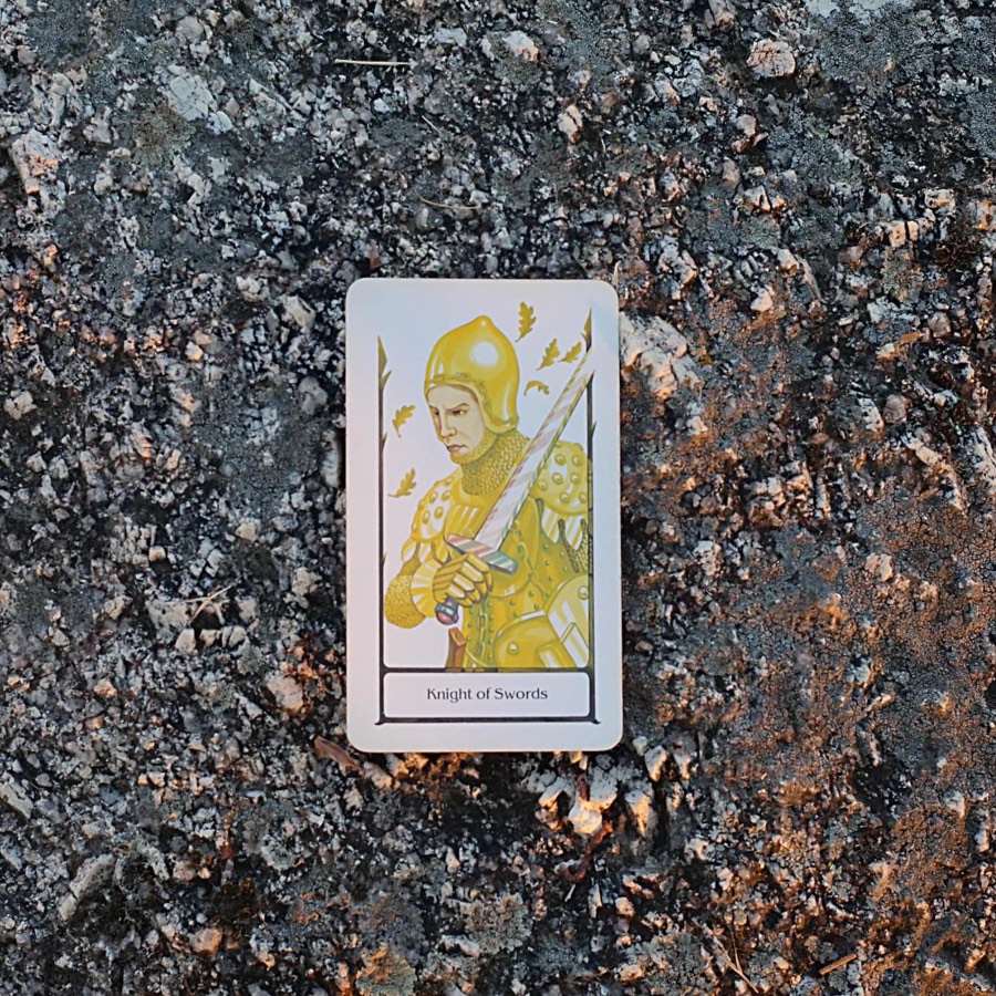 The Knight of Swords tarot card photographed outdoors