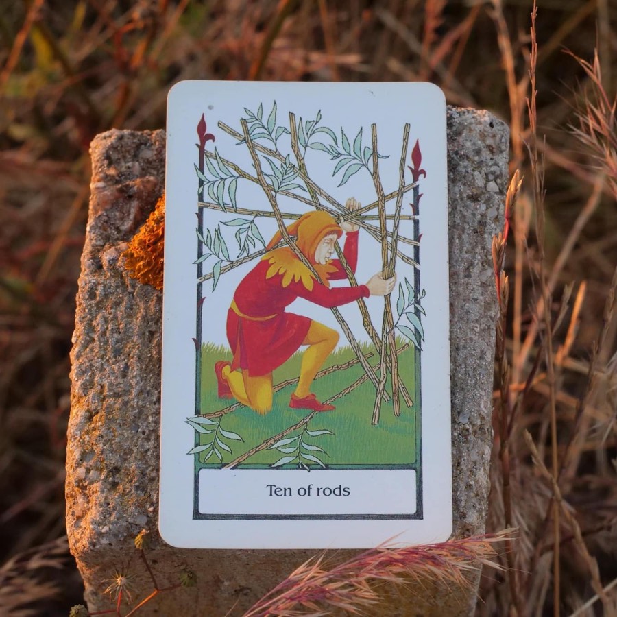 The Ten of Wands tarot card photographed outdoors