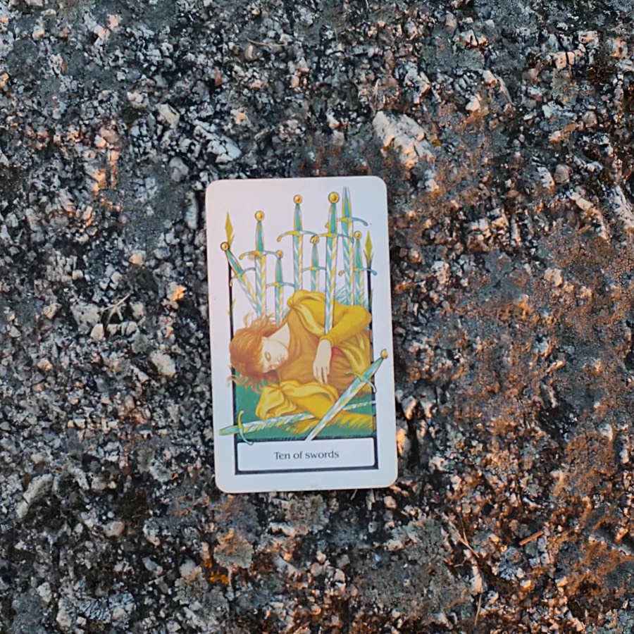 The Ten of Swords tarot card photographed outdoors