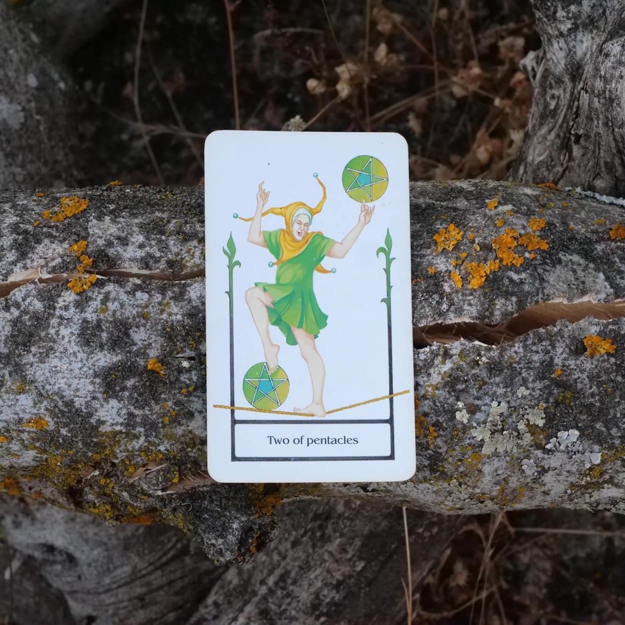 The Two of Pentacles tarot card photographed outdoors