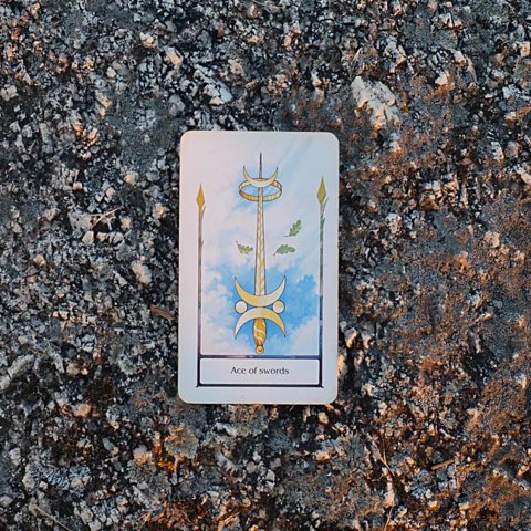 Ace of Swords tarot card, photographed outdoors