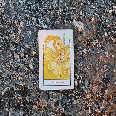 Two of Swords tarot card, photographed outdoors