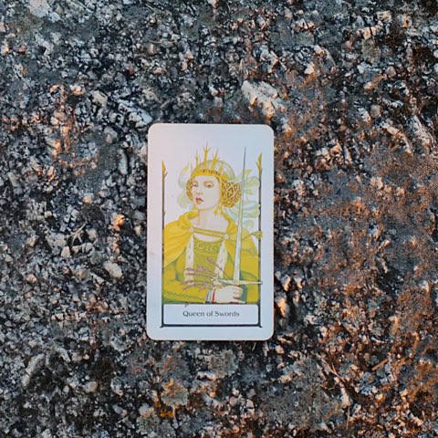 Queen of Swords tarot card, photographed outdoors