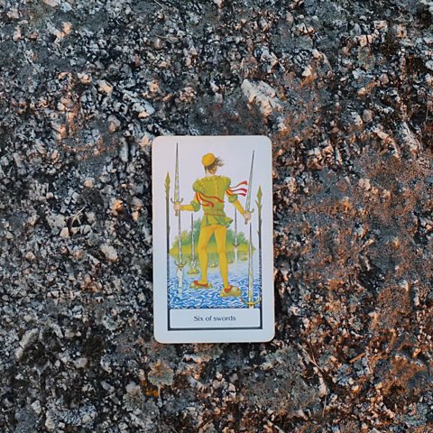 Six of Swords tarot card, photographed outdoors