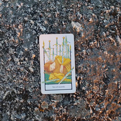 Ten of Swords tarot card, photographed outdoors