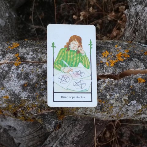 Three of Pentacles tarot card, photographed outdoors